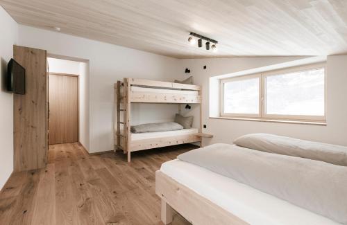 a bedroom with two bunk beds and a window at Ferienhaus Schihütte Mellau in Mellau