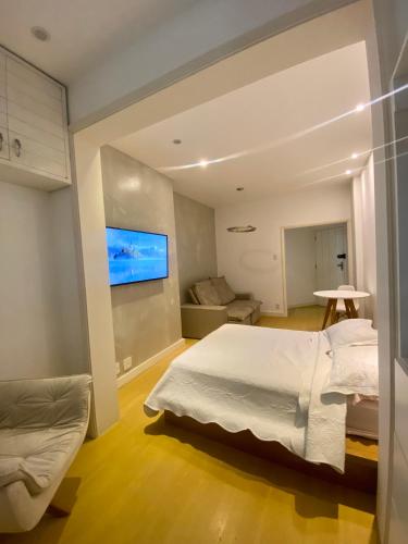een slaapkamer met een bed en een tv aan de muur bij Apartamento Encantador Leme - Prédio na Orla in Rio de Janeiro