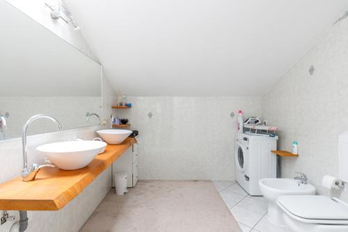 a bathroom with two sinks and a washing machine at Elly's Home [Parcheggio Privato] in Ravenna