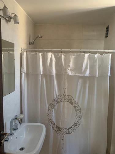 baño con cortina de ducha blanca y lavamanos en Balcarce 526 en Córdoba