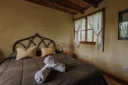 a bedroom with a bed with towels on it at Cabañas en el Bosque a 5 minutos del mar - Estancia CH in Punta del Este