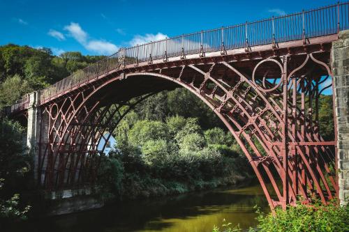 a bridge over a river with a train on it at Best Western Valley Hotel in Ironbridge