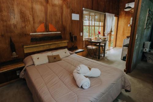 a bedroom with a large bed with towels on it at Cabañas en el Bosque a 5 minutos del mar - Estancia CH in Punta del Este