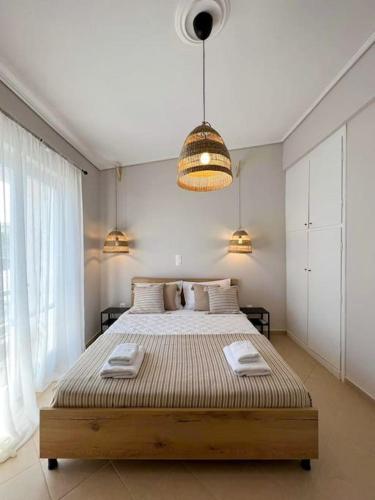 sypialnia z dużym łóżkiem z dwoma ręcznikami w obiekcie Mimosa House w mieście Gythio