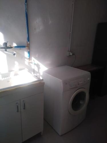 a bathroom with a washing machine and a sink at Il Glicine di Villa Vittoria nel verde a pochi minuti di auto dalle spiagge in Borgonovo