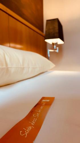 a bed with a sign on it with a lamp on it at Salischer Hof in Schifferstadt