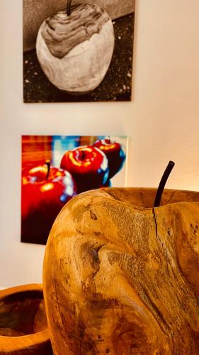 a wooden bowl with apples sitting on a table at Salischer Hof in Schifferstadt