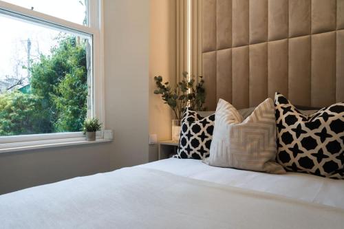 um quarto com uma cama com almofadas e uma janela em The Wilton Suite - Your Private 5* Escape! em Glasgow