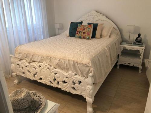 1 cama blanca con almohadas en el dormitorio en Playa Varese-Mar del plata en Mar del Plata