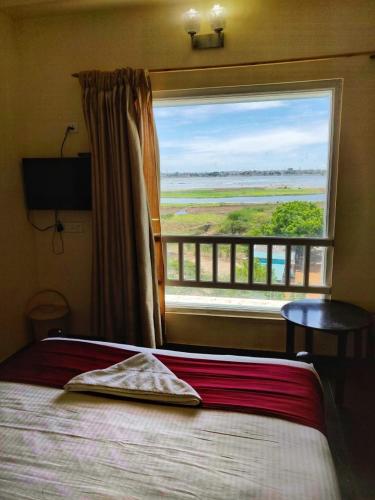 a bedroom with a bed and a large window at Le Grace Apollo in Madurai
