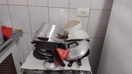 a pile of pots and pans sitting on top of a stove at Casa Mongaguá Plataforma in Mongaguá