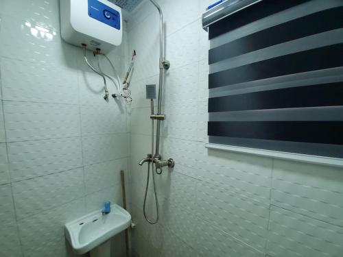 uma casa de banho com um chuveiro e um WC. em DINERO JADE - One Bedroom Apartment em Lagos