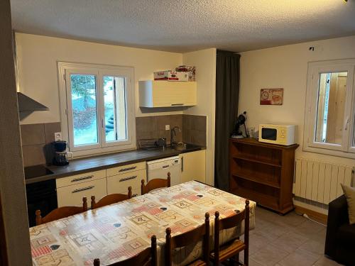 a kitchen with a table and a dining room at Chalet 6 personnes Gentiane in Les Orres