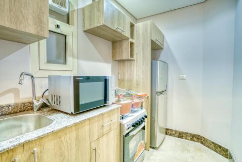 a kitchen with a sink and a tv on a counter at LOFTS by Elegant Hospitality in Cairo