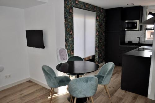 a dining room with a table and four chairs at II Precioso apartamento con vistas a la Catedral in Salamanca