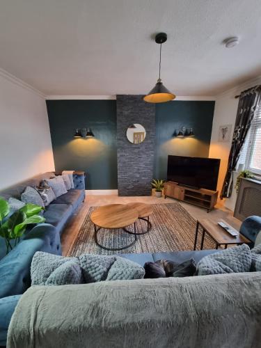 uma sala de estar com um sofá e uma mesa em The View Sandbach em Sandbach