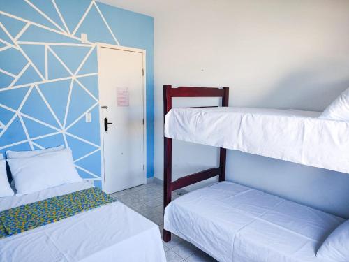 Maré Hostel Itapuã في سلفادور: سريرين بطابقين في غرفة مع باب