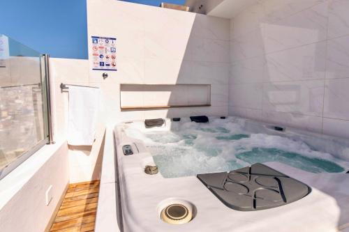 a bathroom with a bath tub with blue water at Penthouse with jacuzzi and sea view, Morabeza Deluxe in Mindelo