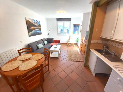 a kitchen and a living room with a table and a couch at Plaza Andalucía Edificio Salvia in Monachil