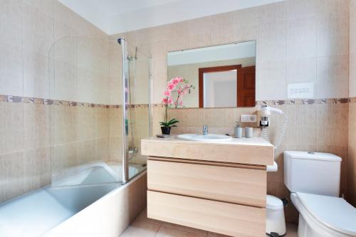 een badkamer met een wastafel, een bad en een toilet bij VILLA RENATO in Playa Blanca
