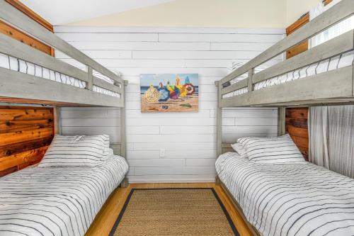 two bunk beds in a bedroom with white walls at Dewey Beach 102 Jersey St in Dewey Beach