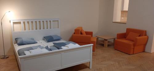een slaapkamer met een bed en 2 oranje stoelen bij Apartman Josef in Praag