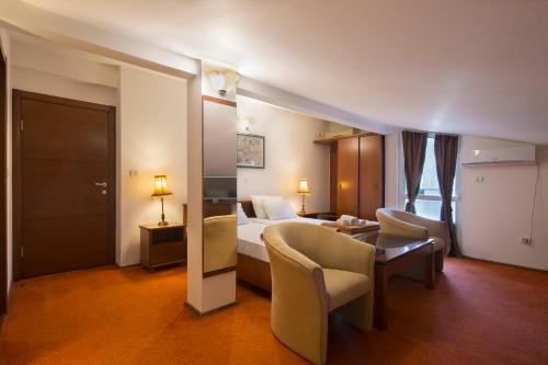 a hotel room with a bed and a table and chairs at Villa Ljubanovic in Budva