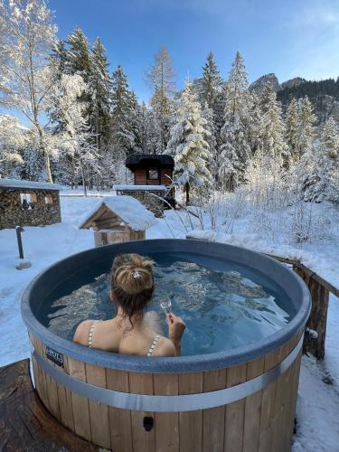 a woman in a hot tub in the snow at Typically Swiss Hotel Ermitage in Kandersteg