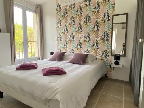 ein Schlafzimmer mit einem Bett mit lila Handtüchern darauf in der Unterkunft Gîte Le Tramontane Le Moulin de Prédelles in Reillanne