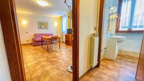 a living room with a table and a pink chair at Appartamento Smith Erbaluce - Affitti Brevi Italia in Bardonecchia