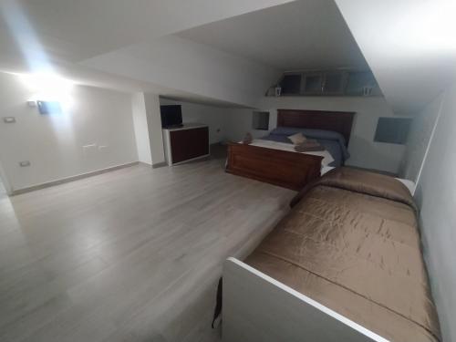 um pequeno quarto com uma cama e piso em madeira em Agriturismo Gusto Nocciola em Bagnoli