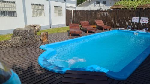 una piscina en una terraza con sillas junto a Citymar Avenida en Villa Gesell