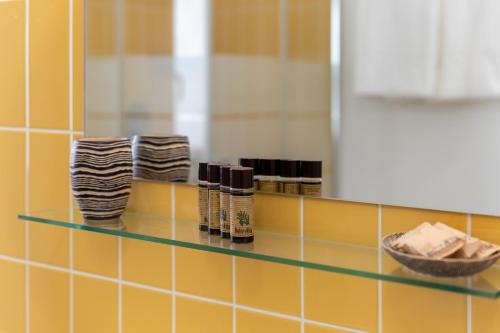 ein Regal in einem Bad mit Pflegeprodukten darauf in der Unterkunft Aparthotel Grel Suite 208 in Chiaramonte Gulfi