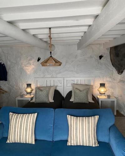 a blue couch in a living room with two lamps at Casa de São João in Fajã de São João