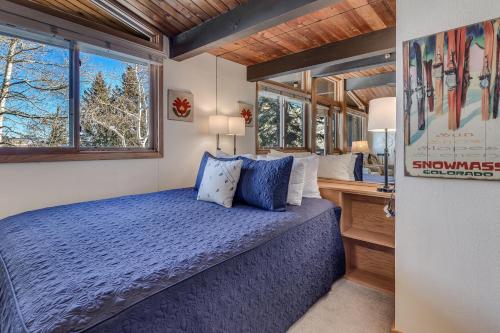 um quarto com uma cama, uma secretária e janelas em Laurelwood Condominiums 113 em Snowmass Village