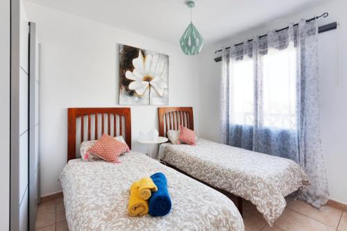 een slaapkamer met 2 bedden en een knuffeldier op het bed bij VILLA RENATO in Playa Blanca