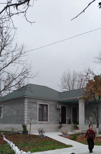 a man walking in front of a house at Gabala rent House in Gabala