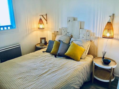 sypialnia z łóżkiem z żółtymi i niebieskimi poduszkami w obiekcie Cabourg T2 tout neuf Accès direct mer Grand balcon w mieście Cabourg