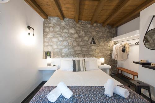 a bedroom with a bed and a stone wall at Mykonos Amazing Apartments 2 in Mikonos