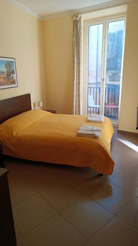 sypialnia z dużym żółtym łóżkiem i dużym oknem w obiekcie B&B Vivaldi w mieście Palermo