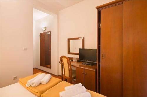 a hotel room with a desk and a television at Villa Ljubanovic in Budva