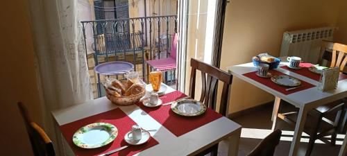 a table and chairs with plates and dishes on it at B&B Vivaldi in Palermo