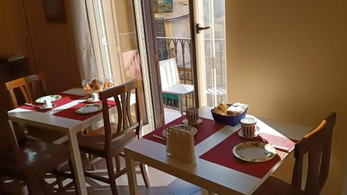 mesa y sillas con mesa y ventana en B&B Vivaldi, en Palermo