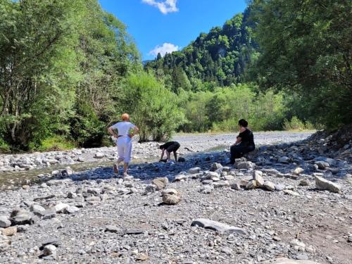 une femme, un homme et un chien sur une rivière rocheuse dans l'établissement Les Espaces Lichens 06, à Samoëns