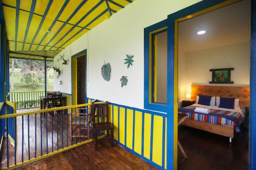 a room with a bedroom with a bed and a balcony at El Rancho de Salento in Salento