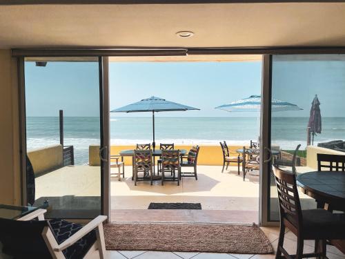 a view of the beach from a patio with tables and umbrellas at OCEAN FRONT - STUNNING VIEWS- VACATION PARADISE!! in Dana Point