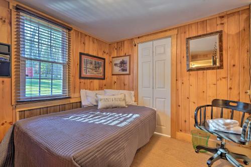 ein Schlafzimmer mit einem Bett, einem Stuhl und einem Fenster in der Unterkunft 3-Acre Lodge with Snowmobile and Four-Wheeling Trails in Coudersport