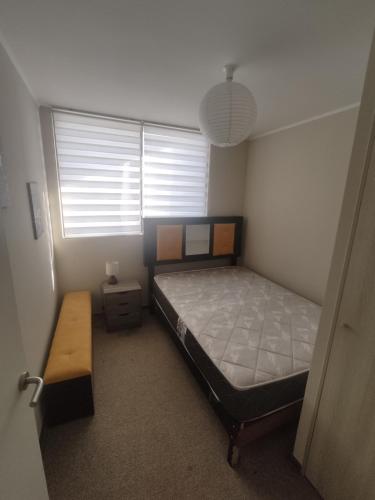 1 dormitorio con cama, mesa y ventana en Departamento por día 3 dormitorios y 2 baños en Arica