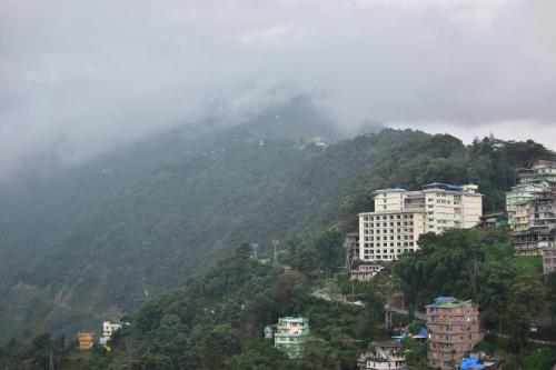 a city on top of a mountain with buildings at HOTEL MONTANA VYOO in Namchi