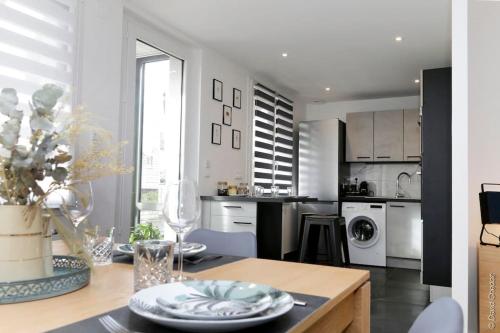 a white kitchen with a table and a dining room at Maison « De Ville en Vigne » in Chenôve